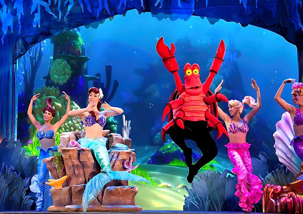 Sebastian the crab with mermaids in sequined tails on an undersea set, Mickey's Music Festival. Costume design by Cynthia Nordstrom