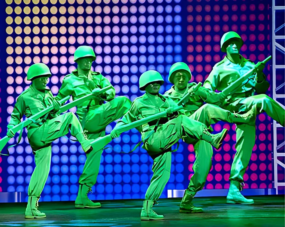 Green army men dancers kicking in formation, Mickey's Music Festival. Costume design by Cynthia Nordstrom