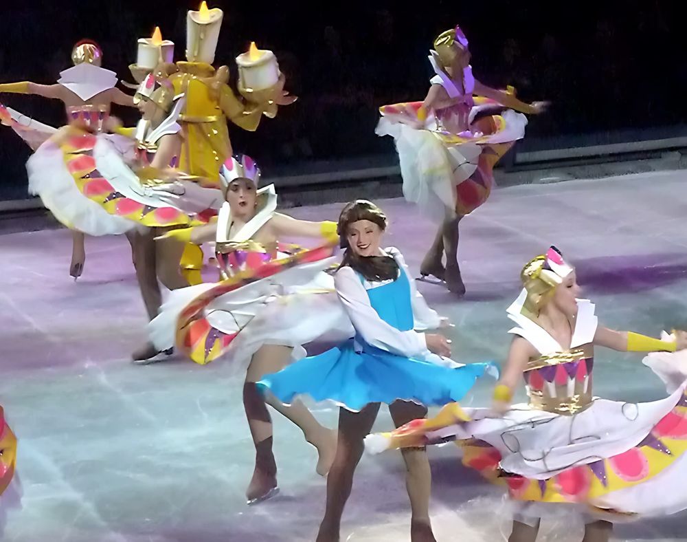 Belle in blue skating with enchanted objects in candle and plate costumes, Rockin' Ever After. Costume design by Cynthia Nordstrom