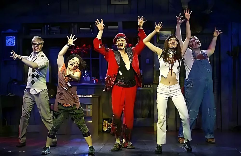Cast in bloodied campwear, overalls and a red jacket mid-song, Evil Dead: The Musical. Costume design by Cynthia Nordstrom