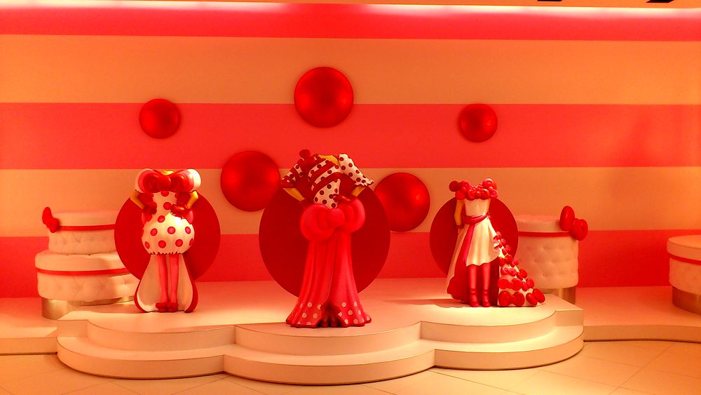Three Hello Kitty couture dresses in red and white on a display stage, Hello Kitty's Wonderland, USJ. Costume design by Cynthia Nordstrom