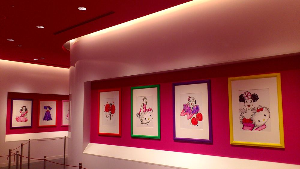 Gallery hall of framed Hello Kitty fashion sketches on pink walls, Hello Kitty's Wonderland, USJ. Costume design by Cynthia Nordstrom