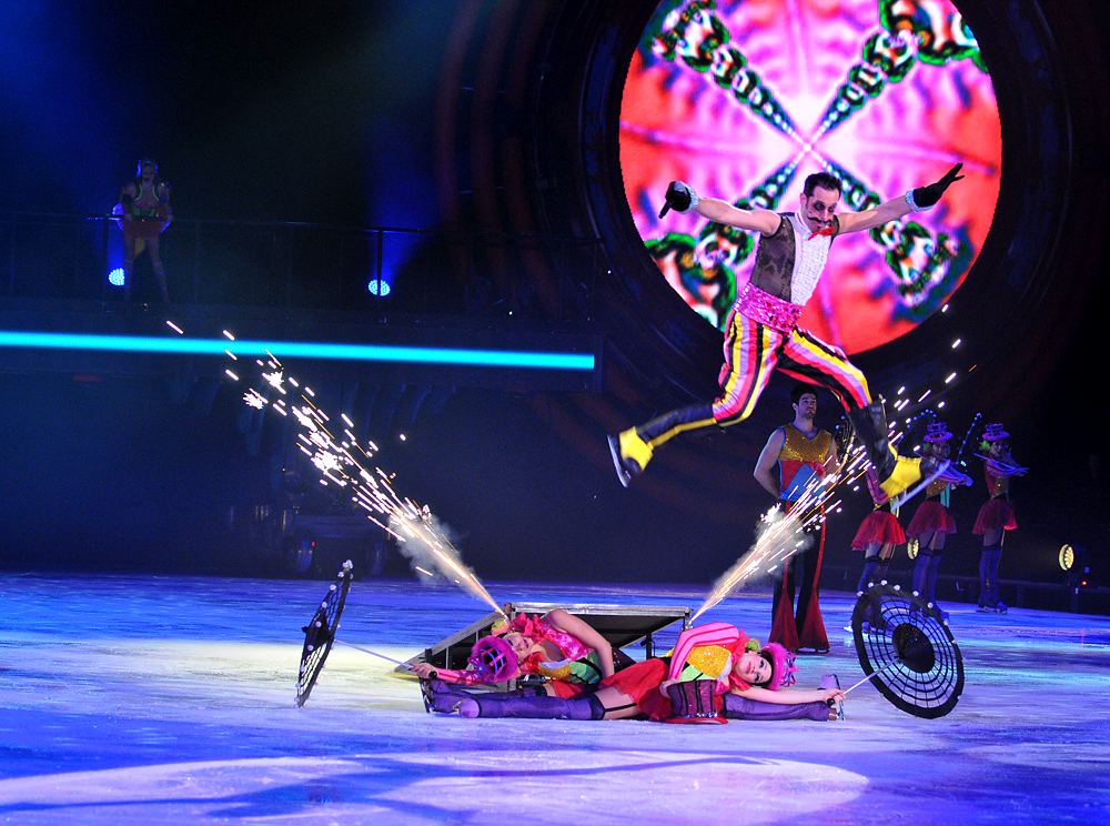 Skater leaping over a fallen performer as sparks fly from skate blades, Holiday On Ice: Speed. Costume design by Cynthia Nordstrom