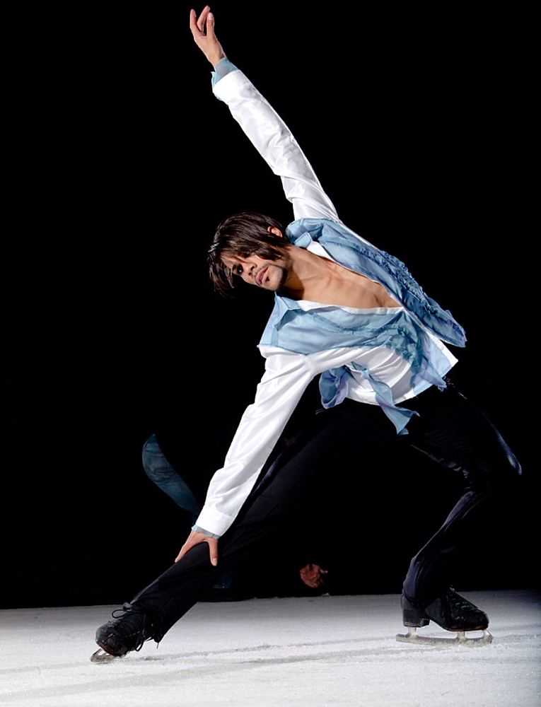 Male skater in a loose white shirt and black pants in a deep lunge, Holiday On Ice: Passion. Costume design by Cynthia Nordstrom