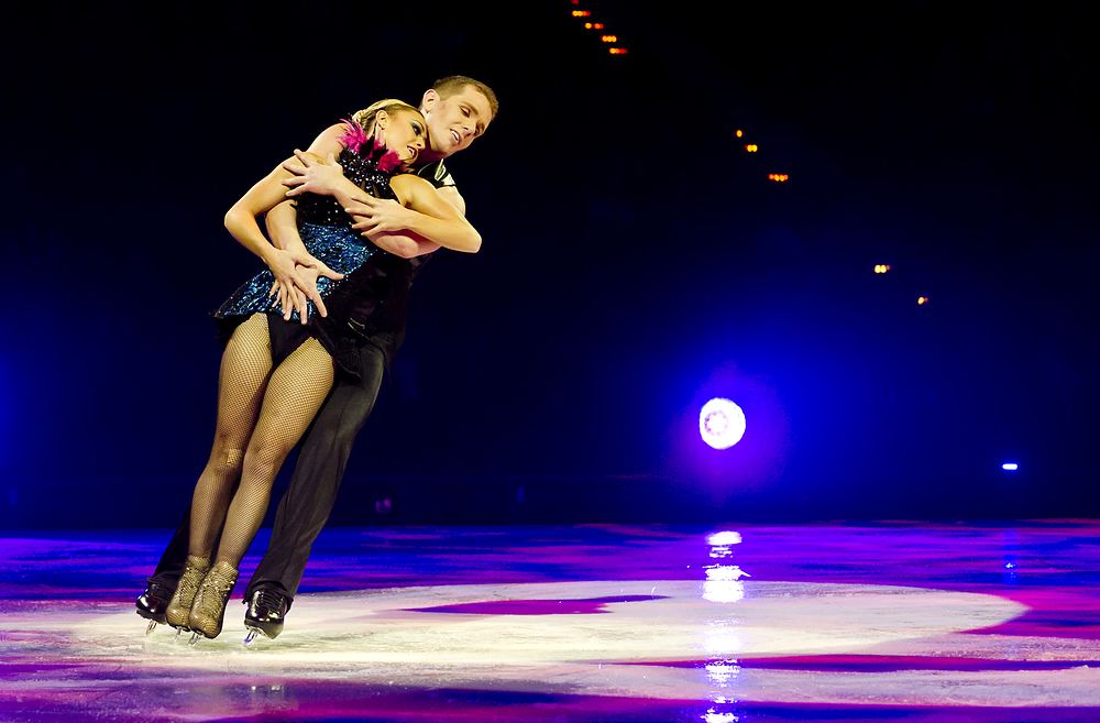Pair skaters in black and purple in a close spin, Holiday On Ice: Passion. Costume design by Cynthia Nordstrom