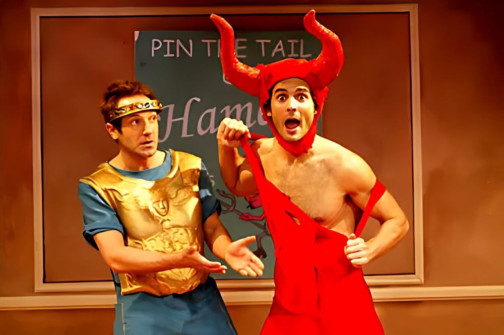 Actor in a red devil costume with horns beside an actor in a gold tunic, Jewtopia. Costume design by Cynthia Nordstrom