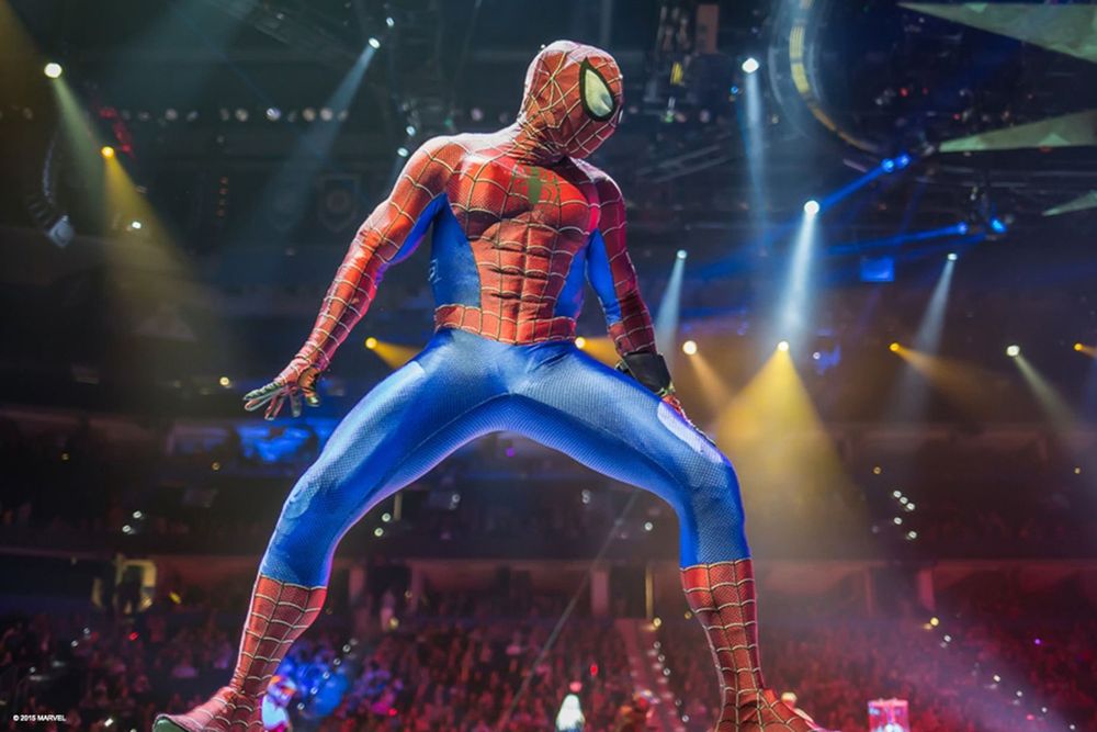 Spider-Man in a red and blue suit crouched center stage in the arena, Marvel Universe Live. Costume design by Cynthia Nordstrom