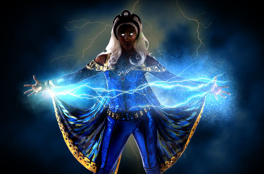 Storm with white hair in a blue and gold caped suit with lightning effects, Marvel Universe Live. Costume design by Cynthia Nordstrom