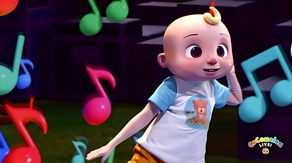JJ walkaround character in a white tee and orange shorts with music notes, CoComelon Live!. Costume design by Cynthia Nordstrom