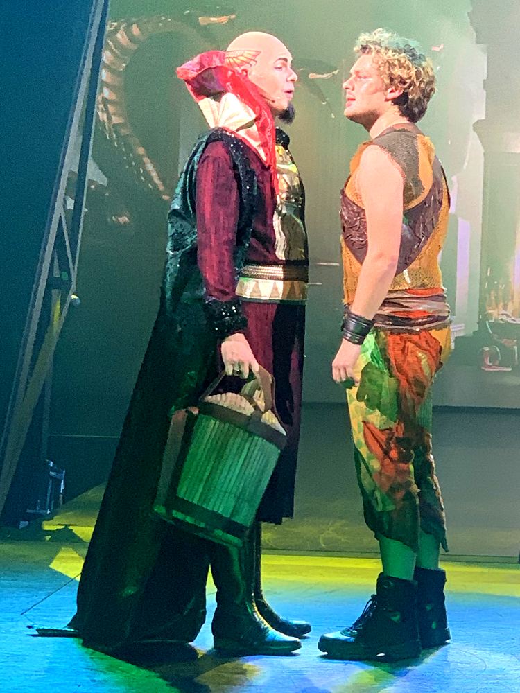 Bald villain in a red and black robe with a lantern beside a young hero, ONE de Musical. Costume design by Cynthia Nordstrom