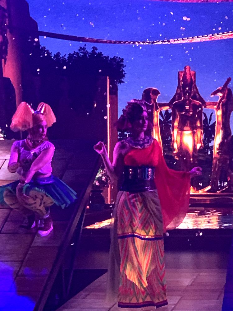 Woman in a black and red bodice and long skirt on a starry set, ONE de Musical. Costume design by Cynthia Nordstrom