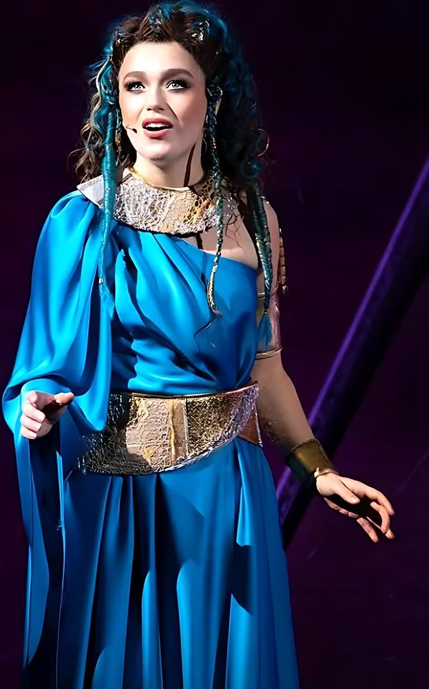 ONE de Musical: a performer in a blue gown on stage. Costume design by Cynthia Nordstrom