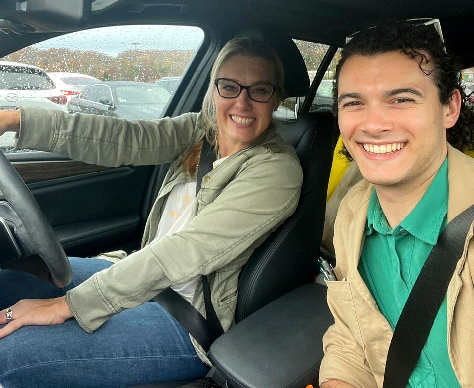 Cynthia Nordstrom and a friend smiling in the front seat of a car