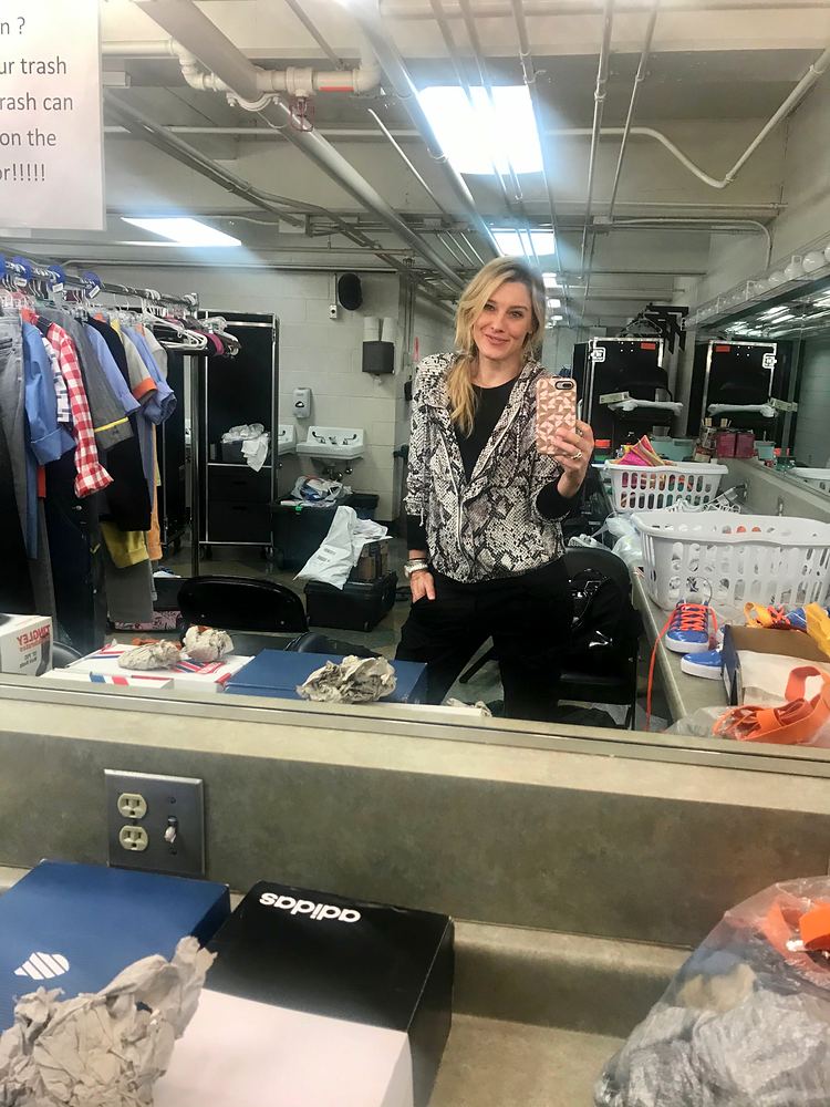 Cynthia Nordstrom sitting on a counter in a costume shop