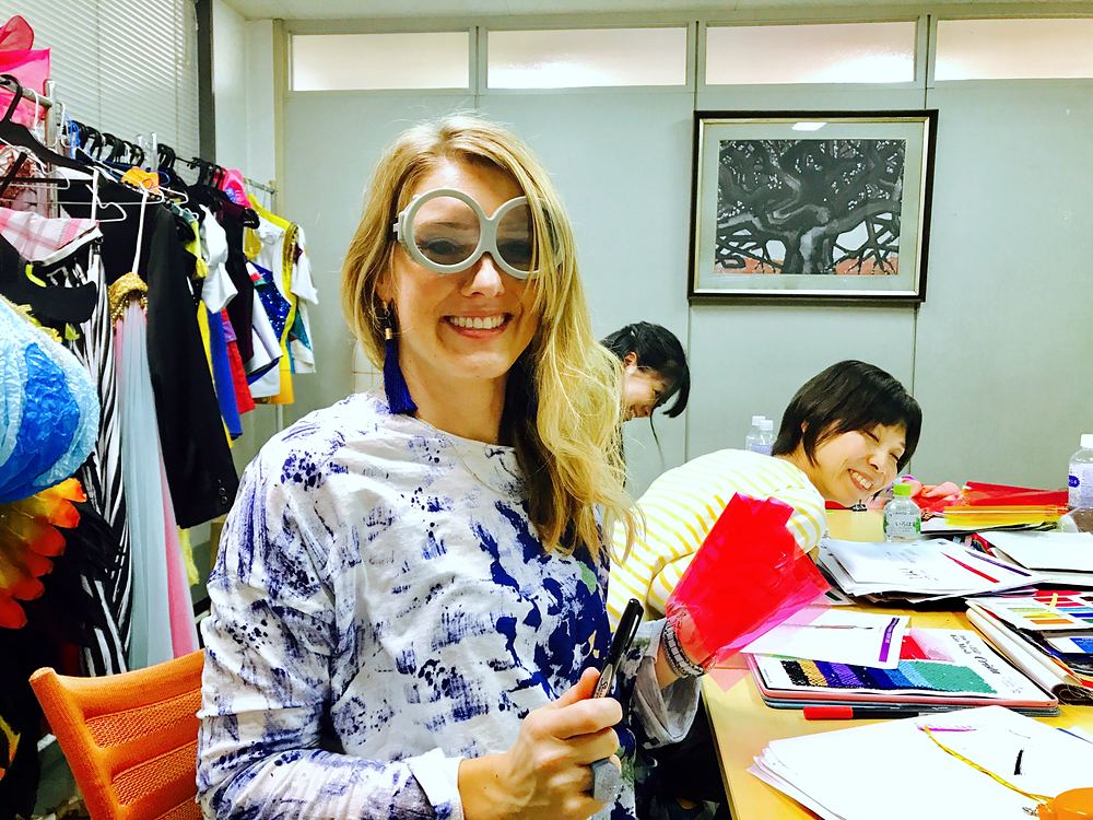 Cynthia Nordstrom in sunglasses at a design table covered with costume sketches