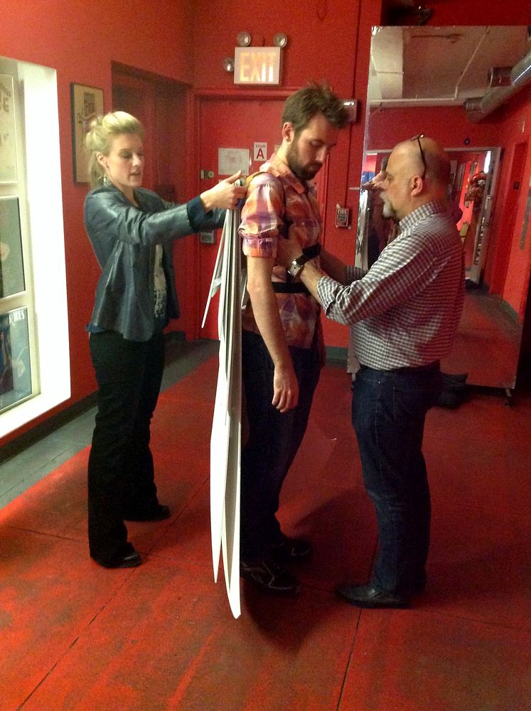 Cynthia Nordstrom fitting a costume piece on a performer