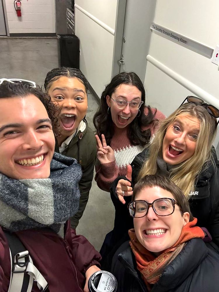 Group selfie of Cynthia Nordstrom and friends laughing in a hallway