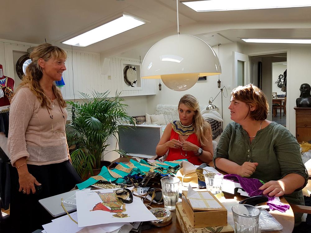 Cynthia Nordstrom with colleagues around a worktable of fabric and costume materials