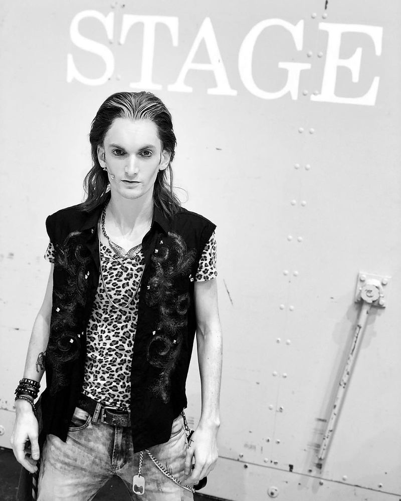 Rocker in a black vest over a leopard-print shirt and jeans, Rock of Ages. Costume design by Cynthia Nordstrom