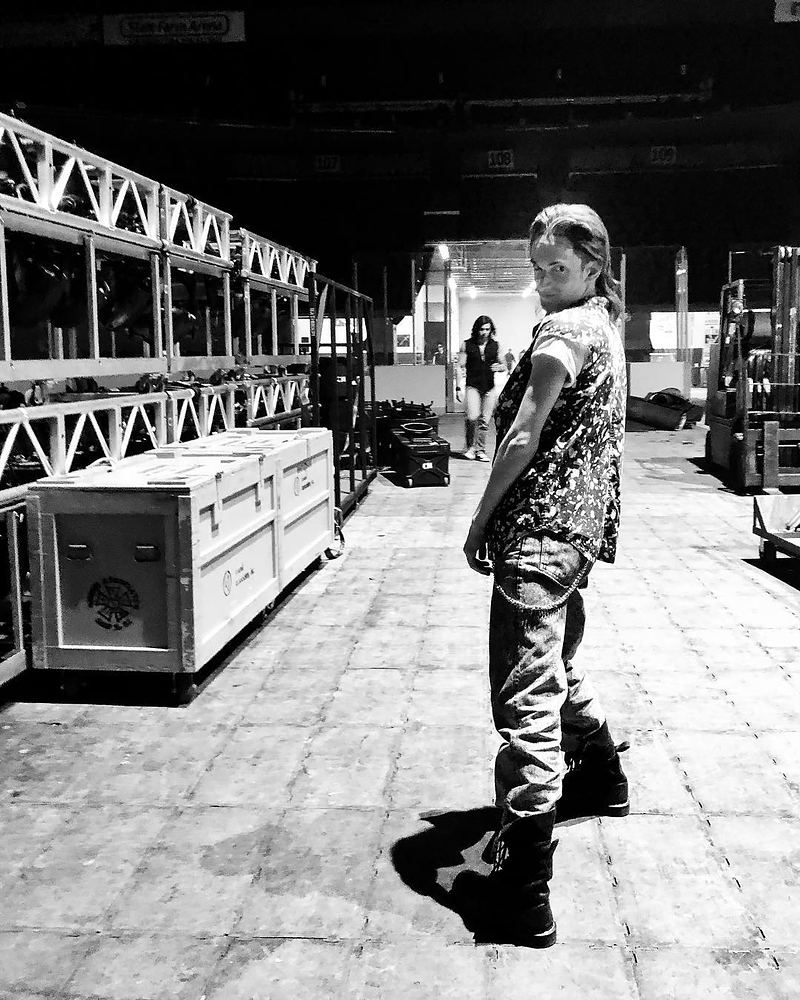 Performer in a patterned top, ripped jeans and boots backstage, Rock of Ages. Costume design by Cynthia Nordstrom