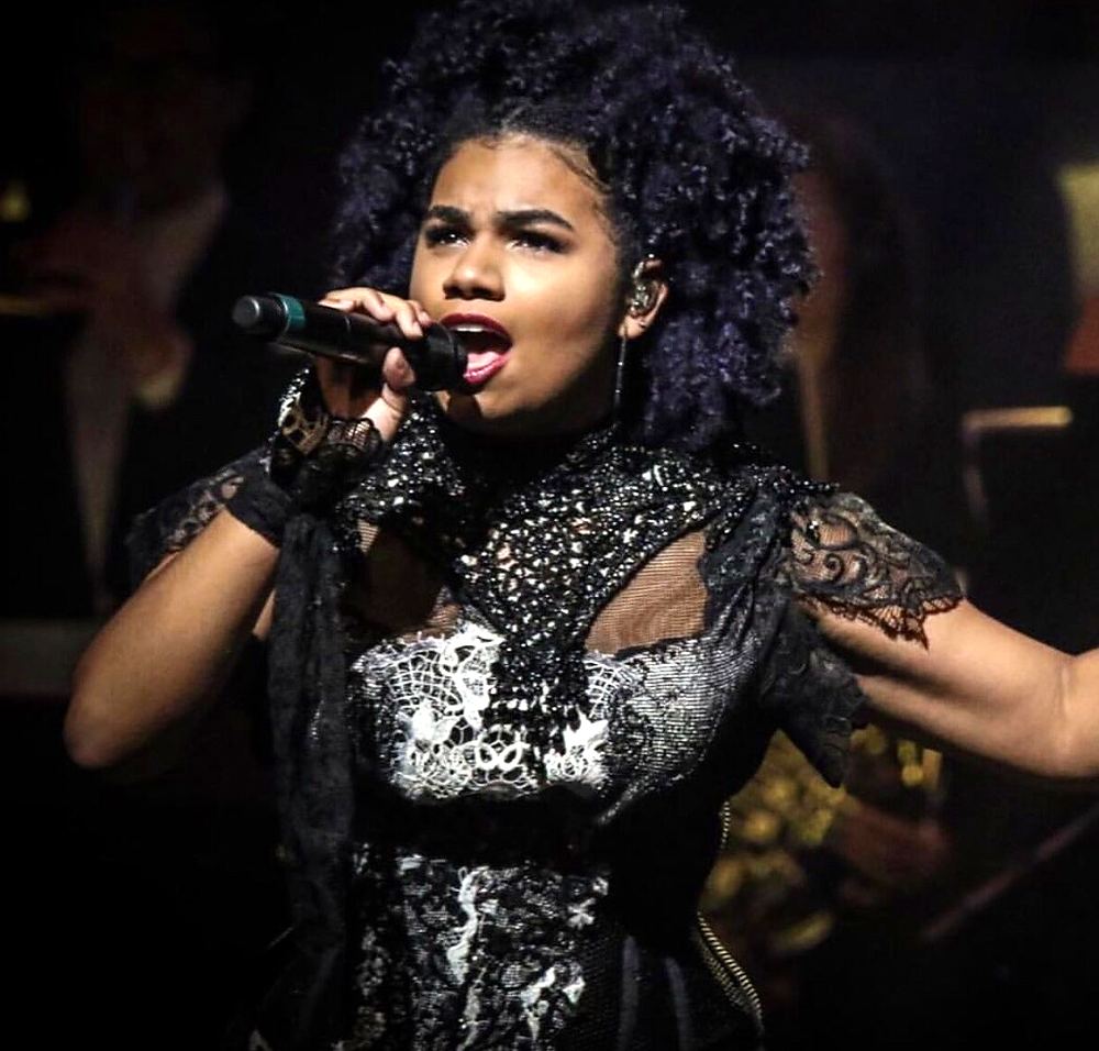 Singer with natural curls in a black and white lace gown, Rocktopia. Costume design by Cynthia Nordstrom