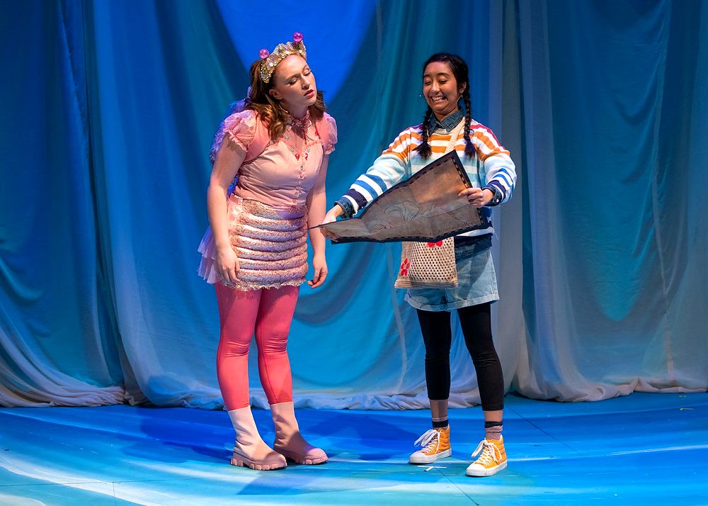 Two girls in a pink striped outfit and a mermaid tail print skirt, Spells of the Sea. Costume design by Cynthia Nordstrom