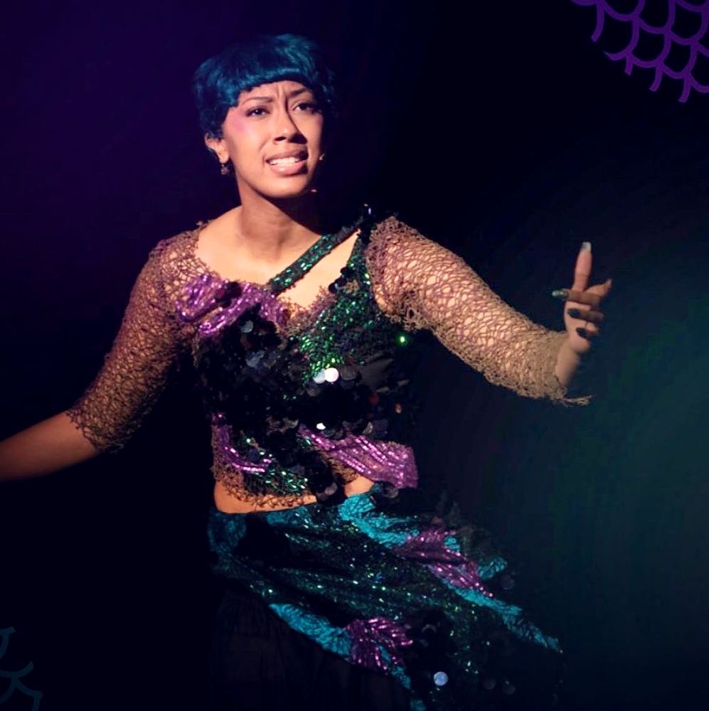Mermaid in a sheer sleeve top covered in teal and purple sequins, Spells of the Sea. Costume design by Cynthia Nordstrom