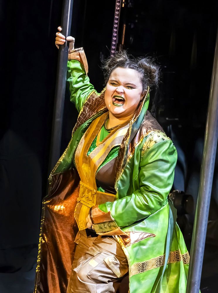 SuperYou at Curve, Leicester: a hero in a long green coat. Costume design by Cynthia Nordstrom
