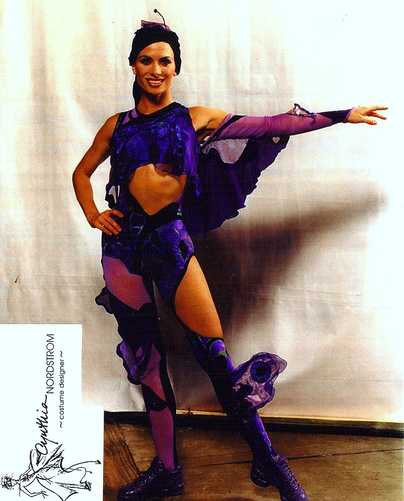 Performer in a purple bird-inspired costume with feathered wings and boots, Tarzan Rocks!. Costume design by Cynthia Nordstrom