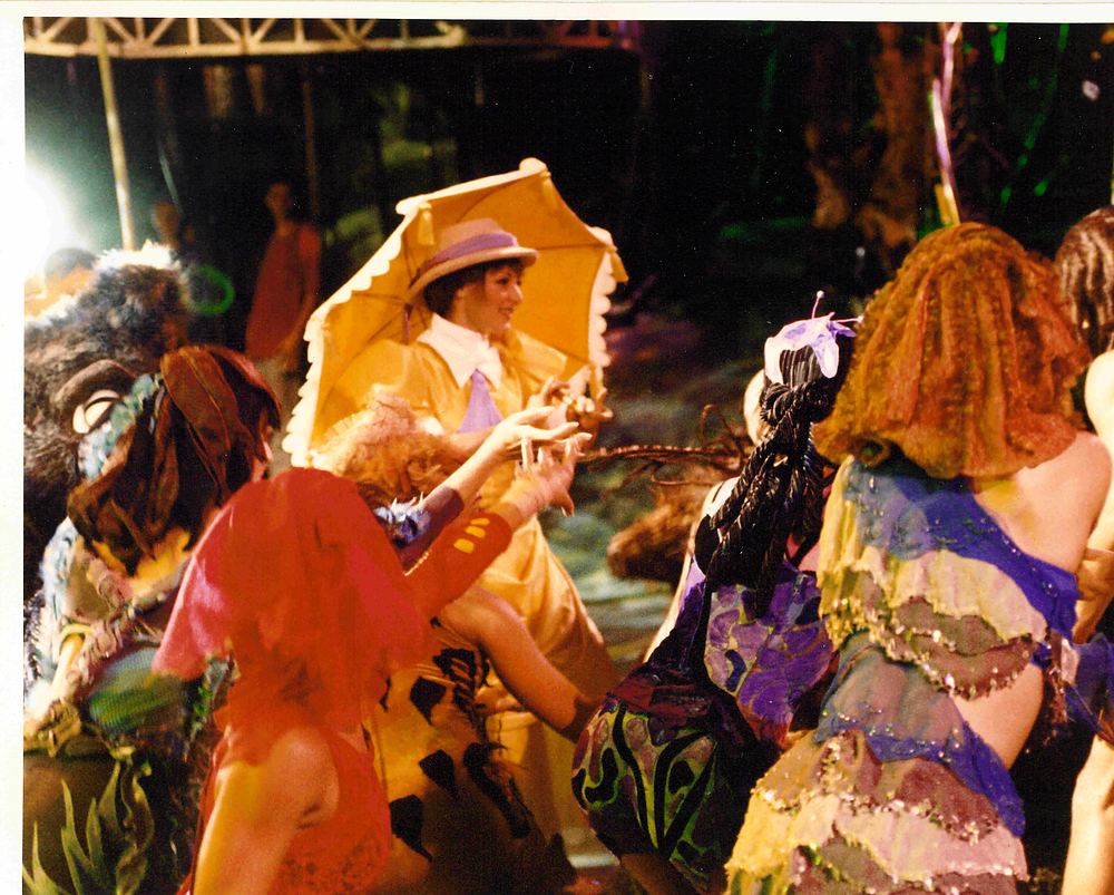 Jungle ensemble in ruffled, tattered costumes with Jane and her yellow parasol, Tarzan Rocks!. Costume design by Cynthia Nordstrom
