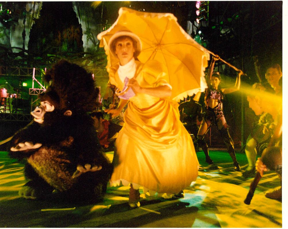 Jane in a yellow Victorian gown with parasol beside a gorilla, Tarzan Rocks!. Costume design by Cynthia Nordstrom