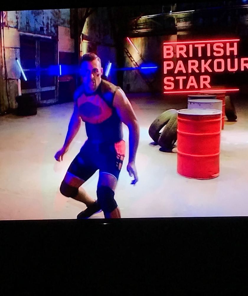 TV still of a tagger in blue on the arena set, labeled British Parkour Star, Ultimate Tag (FOX). Costume design by Cynthia Nordstrom