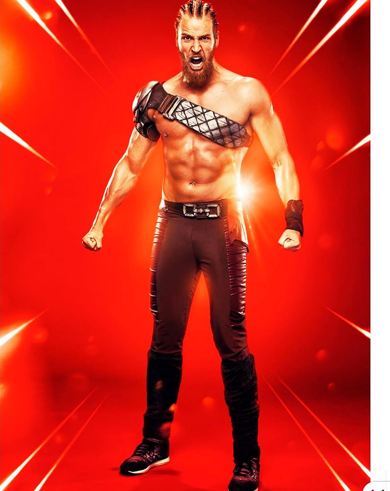 Bearded tagger in a quilted shoulder harness and black pants, Ultimate Tag (FOX). Costume design by Cynthia Nordstrom