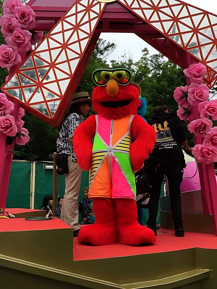 Elmo in neon sunglasses and a bright patterned vest on a pink float, USJ anniversary shows. Costume design by Cynthia Nordstrom