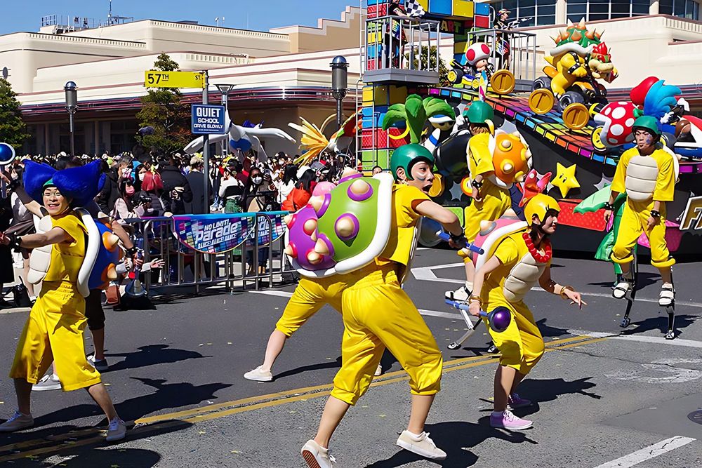 Dancers in yellow outfits and caps with Koopa shell props, NO LIMIT! Parade, USJ. Costume design by Cynthia Nordstrom
