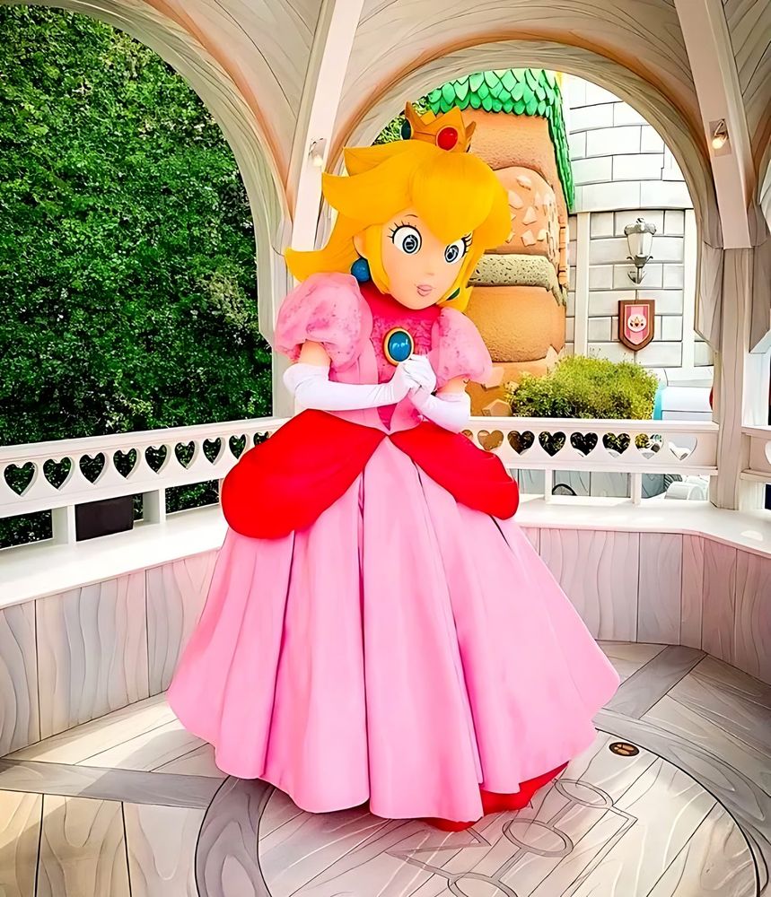 Princess Peach character in a pink gown and crown in a garden gazebo, USJ anniversary shows. Costume design by Cynthia Nordstrom