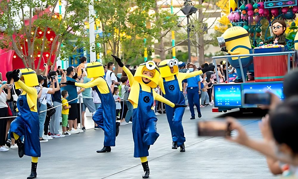 Minion performers in blue overalls dancing on the parade route, Universal Beijing parade. Costume design by Cynthia Nordstrom
