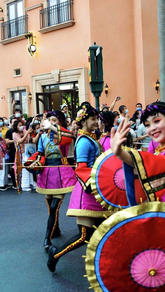 Parade dancers in purple and red with large paper umbrellas, Universal Beijing parade. Costume design by Cynthia Nordstrom